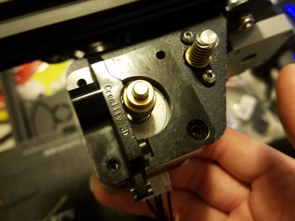 Holding the extruder motor in place, undo the three remaining screws securing the frame in place.