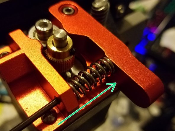 Place your allen key through the outside screw hole to tighten down the first hex screw into the idler arm.