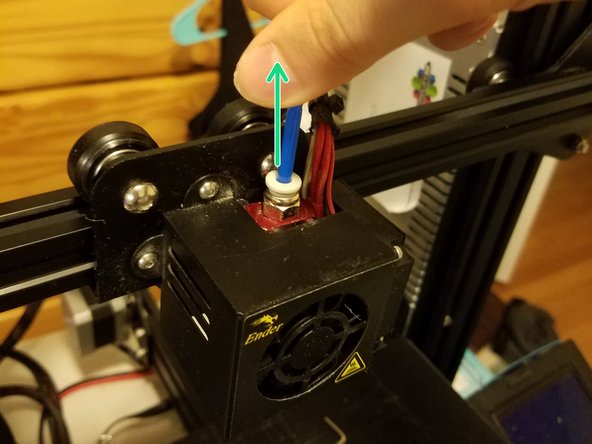 Turn on the printer and heat it to about 210 C, push the plastic ring at the top of the hotend coupling down, and pull the bowden out.