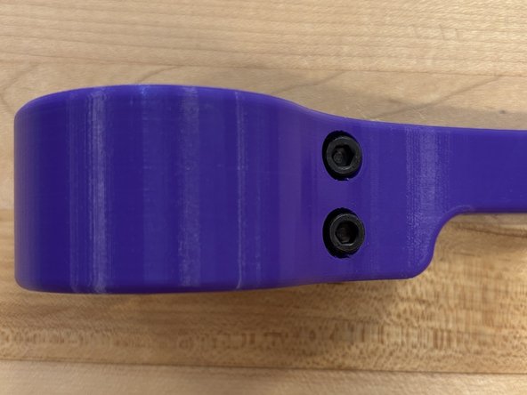 Insert the 2 M5x30mm bolts through the circular holes in the handle