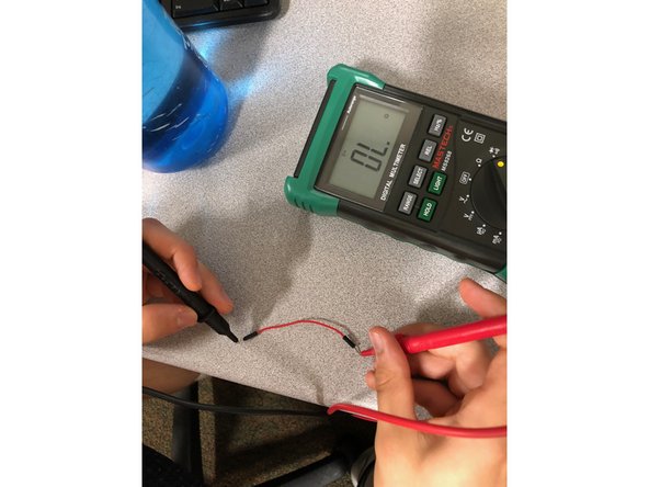 Touch each end of multimeter cords to the metal ends of the wire.