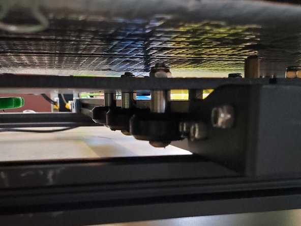 The Print bed is attacked to the printer frame in much the same way as the extruder carriage, but with six symmetrically distributed wheels instead of three unevenly distributed ones