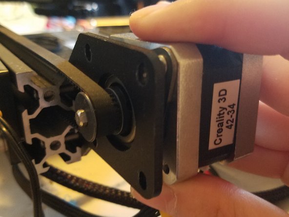 Loop the belt over its gear, then tighten the motor and damper back into place using two of the screws from the upgrade kit