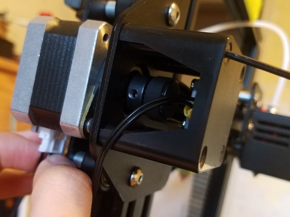 Tighten two of the original screws into the corresponding corners of the dampers, then reconnect the motor.