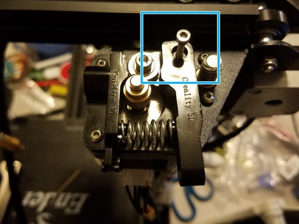 Undo and remove the idler arm screw while holding it in place.