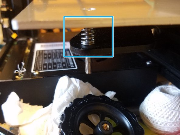 Use the screwdriver to hold the screw in place while you undo the level adjustment wheel so that it comes off of the printer entirely.