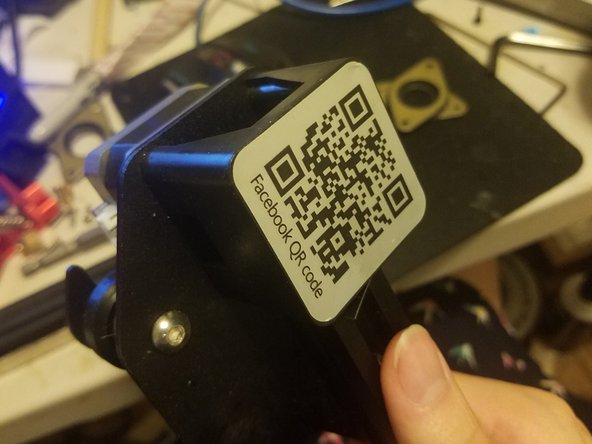 Start by removing this sticker on the left side of your X axis gantry to reveal the four screws holding this stepper motor in place.