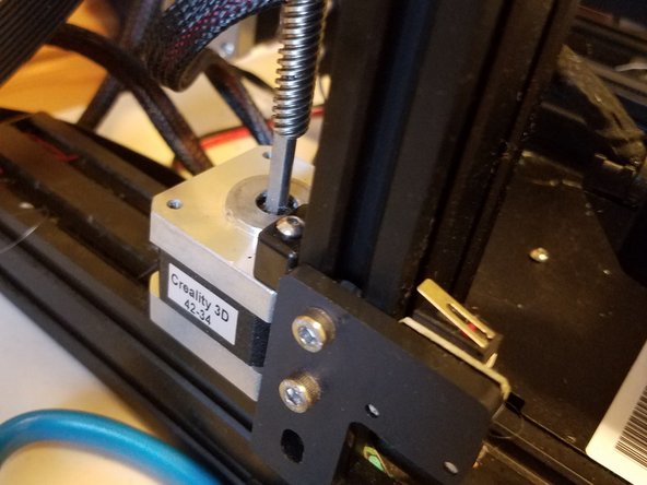 Remove the adaptor from the machine entirely and just let the screw sit on the motor shaft for now