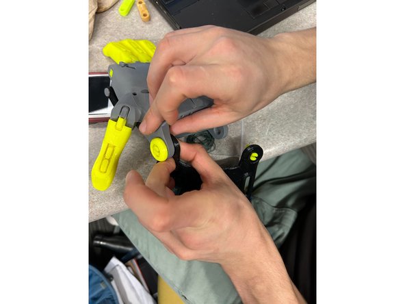 Attach the TPU Thermo Gauntlet (L)  to the hand (K) using the Wrist Pins (F) and the Wrist Caps (H)