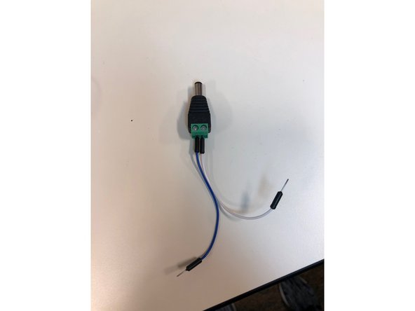 Put a male to male jumper wire into each end of the DC barrel plug, and then attach the j. wire from the positive end, denoted with a positive sign, to the positive alligator clip from the bench power supply and the negative j. wire to the negative alligator clip.