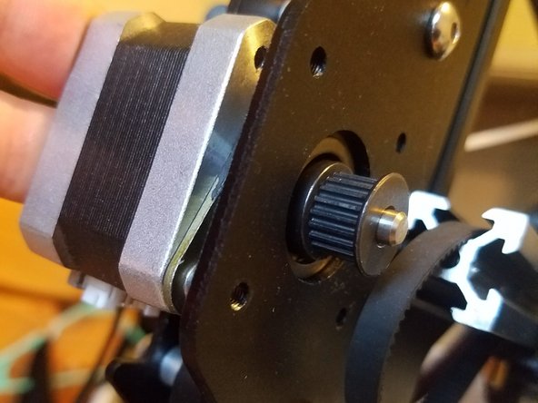 Fit the entire assembly back into its bracket, looping the belt over the gear and tightening its grub screws.