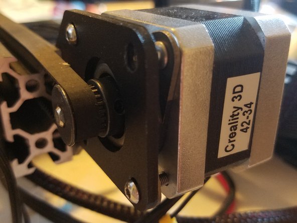 Loop the belt over its gear, then tighten the motor and damper back into place using two of the screws from the upgrade kit