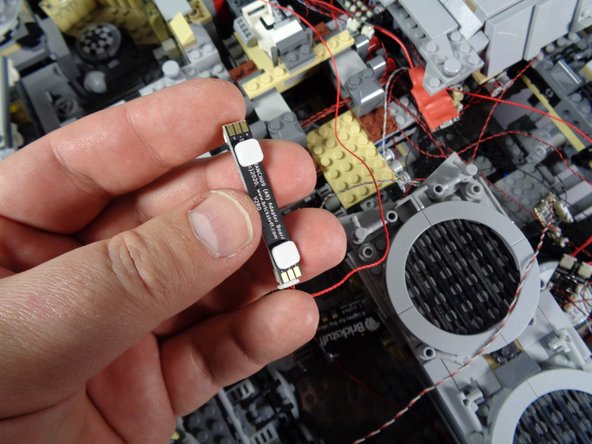 As shown in the second photo, take two small sticky squares from the Main Parts bag and attach them to the back side of the BRANCH09 adapter board.