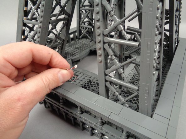 As shown in the first photo for this step, find the loose control cable coming from the first adapter board and first set of light strips.