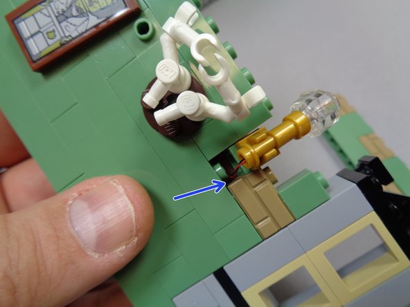 Remove bricks in the bedroom wall so you can access the bricks behind the sconces, then attach the Brickstuff sconces to the wall and run the light wires under the brick and to the side of the stud as shown by the blue arrow in the first photo.