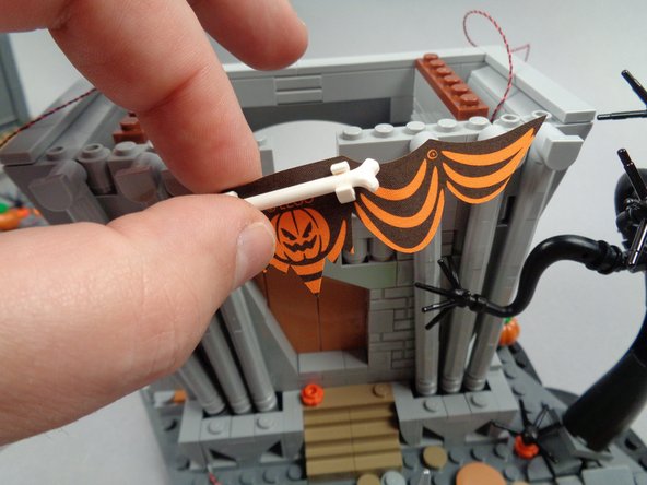 As shown in the photo for this step, remove the banner assembly from the front of the town hall.