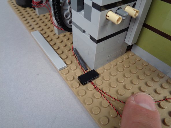 The LEGO parts bag in your BOX #1 includes multiple 1x2 tiles (the tiles shown in these photos are black, but the tiles in your kit may be black or another color).