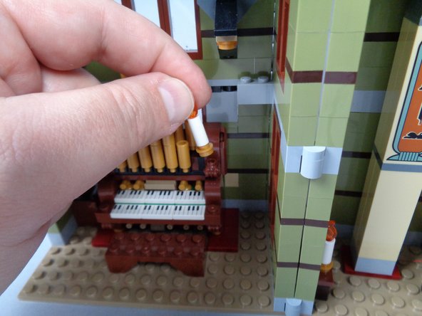 As shown in the photos for this step, remove both candles from the organ, and remove the gold base plate from each candle.