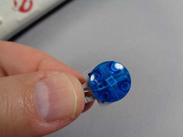 As shown in the third photo for this step, carefully begin re-assembling the hood spot light, making sure the LED light is in the center and that its wires are not pinched by any studs.