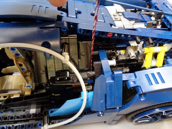 As shown in the third photo, carefully pull both cables up toward the top of the car.