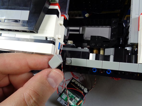 As shown in the first photo for this step, remove the leftmost 1x2 light bluish gray slope from the door frame.