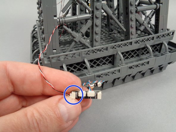 As shown by the blue circle in the photo for this step, select another light strip pair and adapter board, and connect the other end of the control cable to the INPUT plug on the next adapter board.