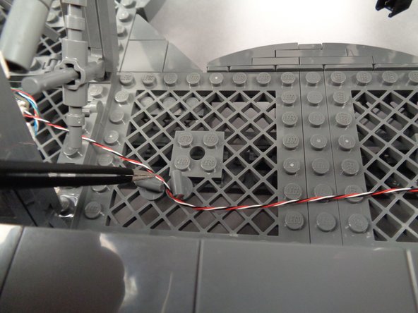 If any control wires are loose passing between any of the pillars, you can use the pieces you removed earlier to secure them as shown in the photos for this step.