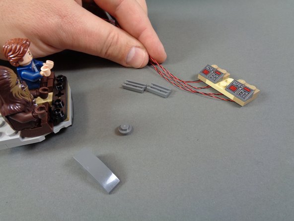 As shown in the photos for this step, mount the modified cockpit control panel inside the cockpit and replace the smaller parts you removed in the last step.