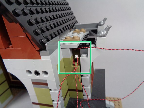 As shown by the green square in the first photo, pull the second front porch light wire out through the same gap in the front wall as you used for the first front porch light wire.