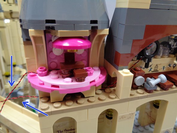 As shown in the first photo, re-attach Umbridge's Office.  You should have the two light wires extending to the left of Umbridge's Office as shown by the blue arrows.