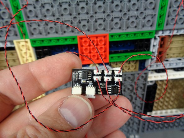 As shown in the photos for this step, connect the wires from the two front door torches to plugs 5 and 6 on the BRANCH09XS adapter board.
