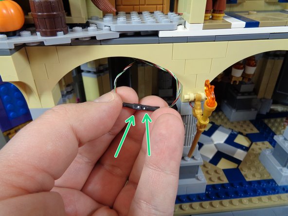 Carefully re-attach the middle section to the bottom section, taking care not to catch either wire between any bricks when you connect the two castle sections.