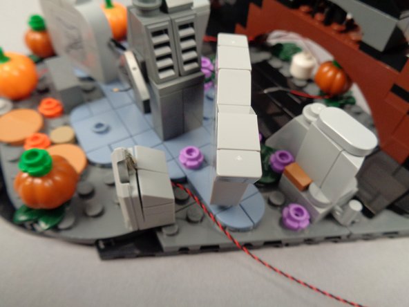 Re-attach the WITCH HAZEL tombstone as shown in the photo for this step, with its LED light wire passing toward the back.