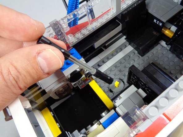 As shown in the photos for this step, remove the vertical interior axle that used to make the roof radar dish rotate.  You will no longer need this, as the roof assembly will now be controlled by the motor.