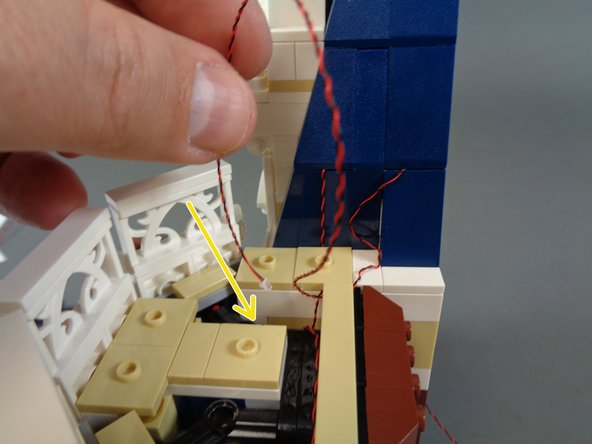 As shown by the red arrows in the second photo, make sure to leave some extra slack in the light wire before re-attaching the tile.  This is critical to prevent the light wire from becoming pinched, stretched, or cut when you attach the top castle section.