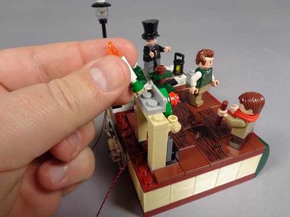 As shown in the first and second photos, remove the two fireplace candles including their green bases.