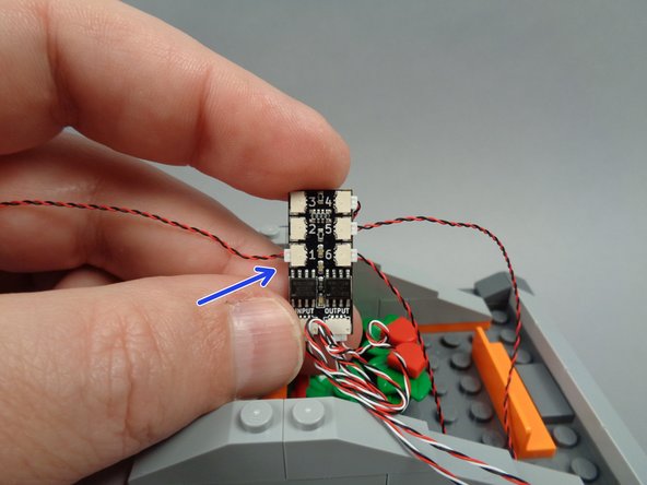 As shown by the arrow in the second photo for this step, connect the spotlight light wire to plug #1 on the BRANCH06X driver board.
