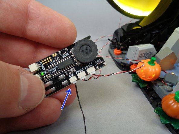 As shown in the second photo for this step, connect one end of the wire to the plug on the button board.