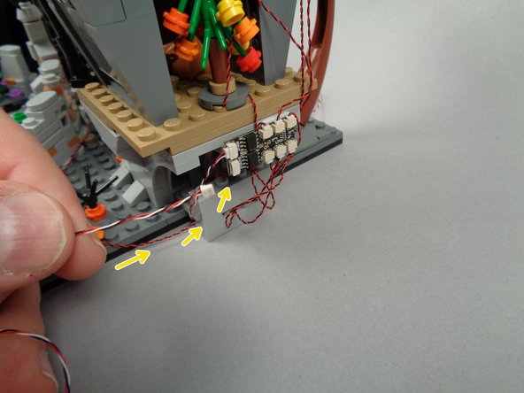 As shown by the yellow arrows in the first and second photos for this step, connect the open end of the control cable coming from the town hall to the OUTPUT plug of the BRANCH06X driver board on the back of Jack's house.