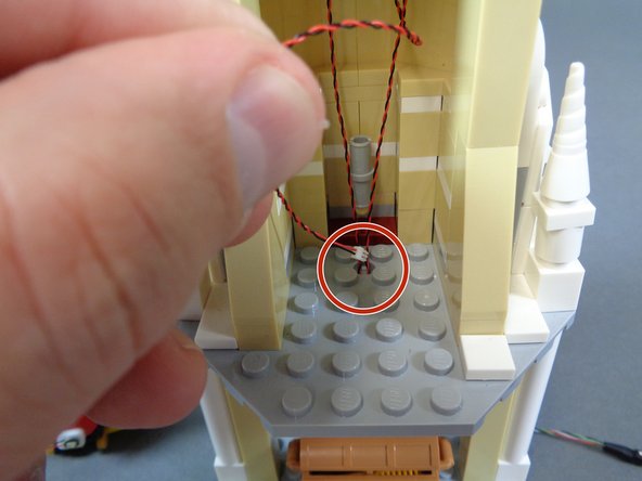 As shown by the red circle in the second photo, pass the wire from the warm white light down through the hole in the floor of the mirror room.