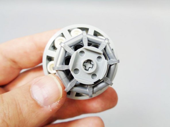 As shown in the second photo, the axle should not extend beyond the bottom of the round plate, but it should extend far enough that it grips the plate.