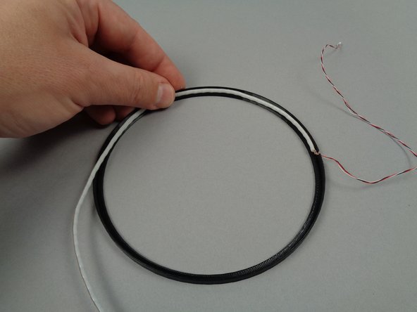 As shown by the green arrow in the first photo for this step, there is a notch in the plastic frame.  This is the location of the bottom of the frame.  Begin mounting the light strip with the wire extending through this notch.