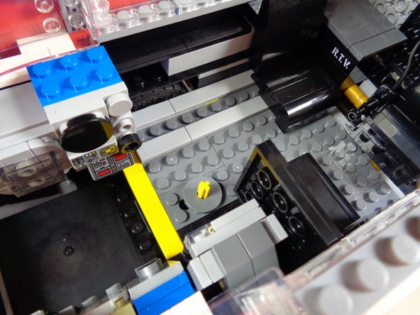 As shown in the photos for this step, remove the vertical interior axle that used to make the roof radar dish rotate.  You will no longer need this, as the roof assembly will now be controlled by the motor.