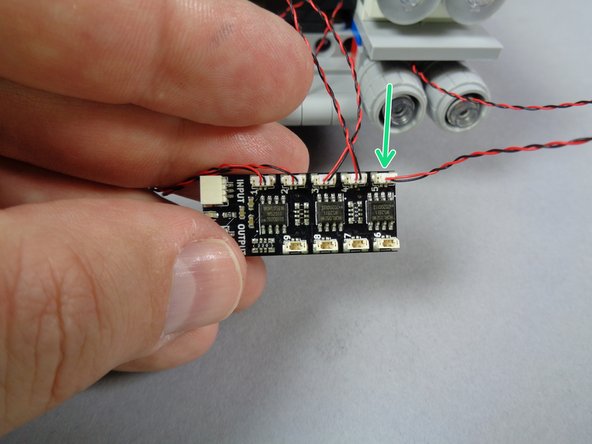 As shown by the green arrow in the second photo for this step, connect the first lower headlight to plug #5 on the BRANCH09X adapter.
