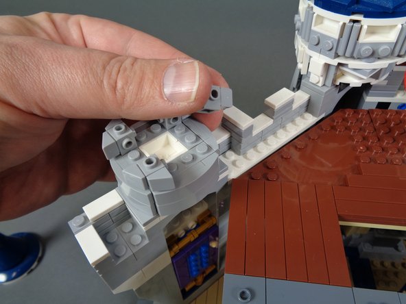 As shown in the photos for this step, remove the top and side pieces from the tower on the left in preparation for mounting the first light.