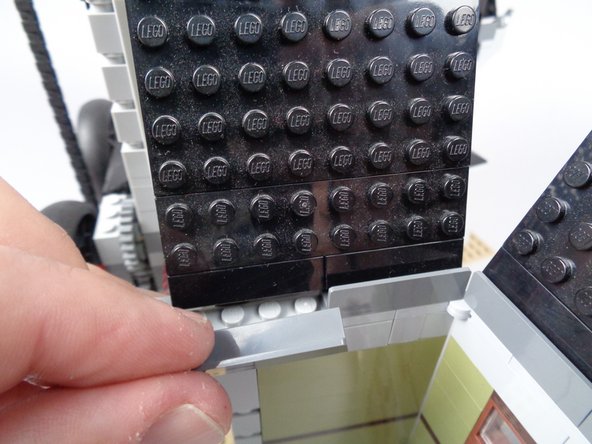 As shown in the photos for this step, re-attach the LEGO parts you removed in the earlier steps to rebuild the wall.