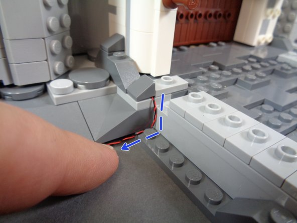 As shown by the blue dotted lines and arrow in the third step, make sure the wire runs down the corner of the rock pieces as close to the back edges as possible.