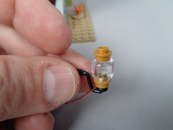 As shown in the second photo, re-attach the clear and top gold parts you removed earlier to the Brickstuff pre-lit light bases.  Do this for both front porch lights.