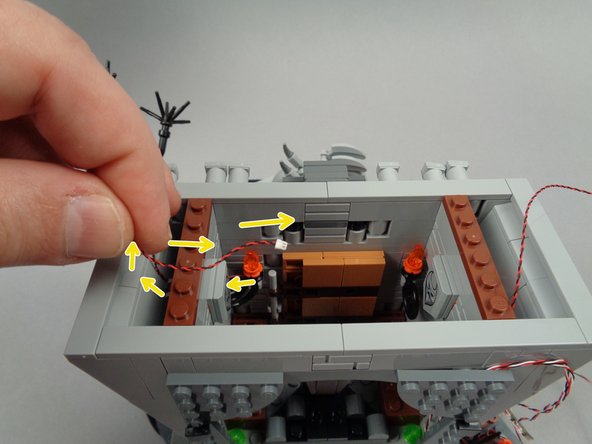 As shown in the first photo for this step, re-attach the second torch and run its wire behind the inner wall section and up out the top of the hall (like you did with the first torch).