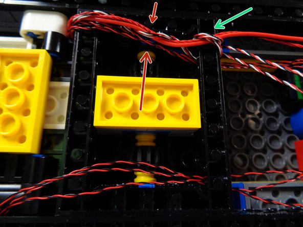 As shown by the green arrow in the first photo for this step, make sure the red roof lights control wire and the motor wire are held tightly against the frame by the two lightbar wires.